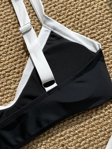 Detail of contrast bikini with adjustable white straps and silver metal buckles