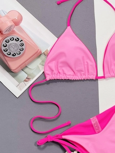 Detail of pink triangle bikini set with contrast piping and 82% polyamide material