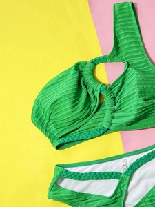 Detail of green ribbed bikini fabric with woven straps and inner lining label