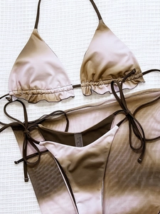 Detailed flat lay of gradient brown to pink three-piece bikini set with sheer mesh sarong