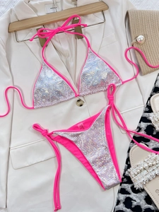 Flat lay di bikini a paillettes olografiche rosa neon con eleganti accessori di moda