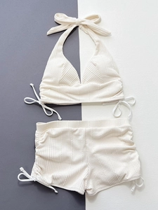 Gros plan sur la texture côtelée blanc crème avec détails de cordon sur ce bikini