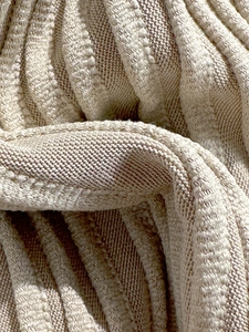 Detailed macro view of the cream ribbed knit fabric texture of this bikini swimsuit
