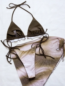 Detailed flat lay of a 3-piece tie-dye bikini set with mesh sarong and washing label