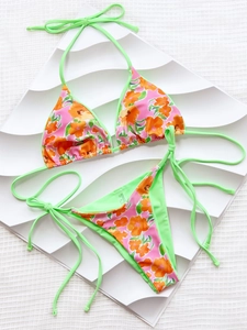 Détail d'un bikini à fleurs avec motif rose et liens contrastants en vert fluo
