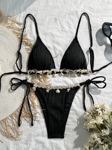 Close-up of black ribbed bikini with shell and starfish charms and white lace trim