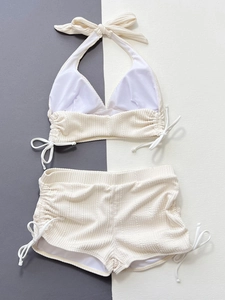 Détails d'un bikini côtelé crème avec haut licou et short à cordon ajustable