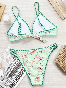 Détail du bikini à fleurs avec bordures festonnées vertes et fermeture à nouer au dos