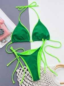 Flat lay of a two-tone green bikini set with neck tie and contrast piping details