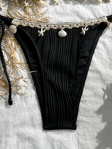 Detail of black ribbed bikini bottoms with seashell and starfish crochet waist belt decor
