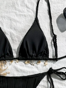 Detail of black ribbed bikini top featuring natural seashell and starfish charms