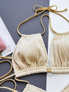 Détail du tissu côtelé beige et du cordon de serrage marron sur le maillot de bain