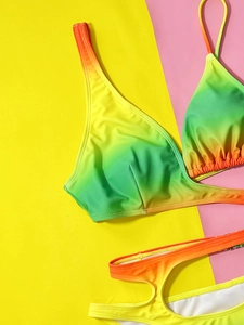 Bikini dégradé à découpes latérales posé à plat sur un fond géométrique très coloré
