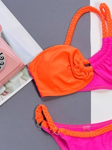 Bright orange and pink two-piece bikini with woven straps and metal ring details