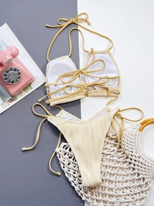 Bikini beige plissé avec haut licou et coupe haute sur fond moderne texturé