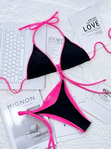 Flat lay of pink and black bikini set with 80% nylon fabric and size S label detail
