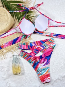 Detail of colorful marble print bikini top and cross-strap bottom on white background