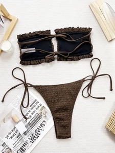 Brown smocked bandeau bikini set with ruffled edges and side-tie thong on white background