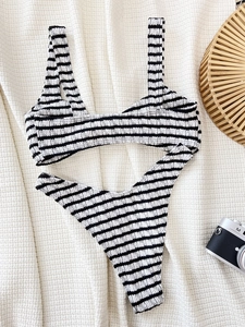 Two-piece black and white striped bikini set with high-cut briefs on a resort background