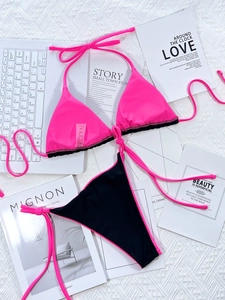 Flat lay of pink and black bikini set with ruffles and nylon spandex fabric details