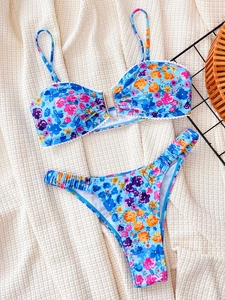 Women's floral bikini set with U-shaped metal ring and strappy top on beige fabric