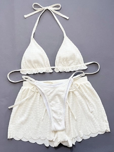 Detailansicht der weißen Smock-Textur eines dreiteiligen Bikinisets mit Rüschen