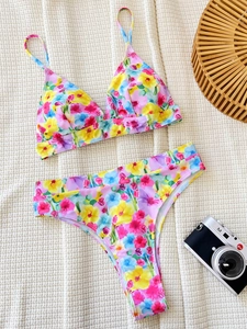Vibrant floral print triangle bikini set with high cut waist bottoms on waffle rug