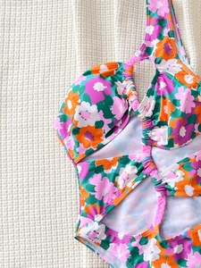 Floral one-piece swimsuit with vibrant tropical print and purple braided straps design
