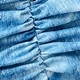 Macro shot of blue textured swimsuit fabric featuring ruched details and gradient wash finish
