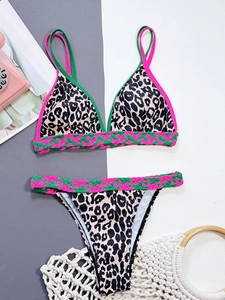 Close-up of leopard print bikini set with pink and green woven trim detail