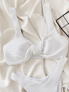 Elegant white ribbed bikini set with front knot top and matching bottoms on waffle fabric