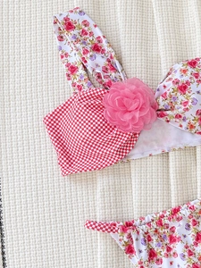 Bikini patchwork a fiori e quadretti con fiore 3D rosa in vista piatta su bianco
