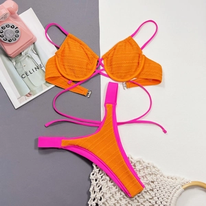 Flat lay of textured orange and pink bikini set with underwire cups and high-cut bottoms