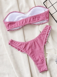 Red and white gingham bandeau bikini set with ruffle detail on flat lay background