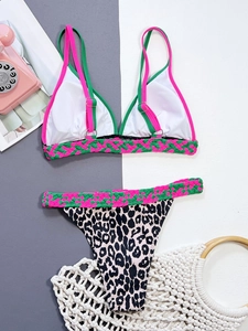 Close-up of leopard print bikini bottoms with pink and green woven strap details