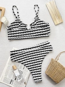Two-piece black and white striped bikini with seersucker texture in a flat lay setup