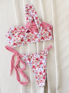 Set bikini monospalla con motivi floreali e a quadretti rosa e rossi