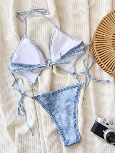 Two-piece denim print bikini set with halter top and side-tie bottoms on textured background
