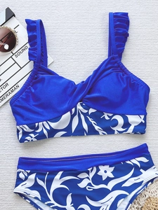 Bikini deux pièces bleu marine avec imprimé floral et bretelles froncées sur fond blanc