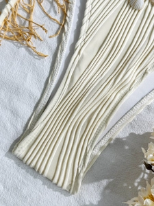 Minimalist beige ribbed bikini bottom with shell charm and lace-up side detail