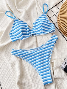 Bikini rayé bleu et blanc avec haut à armatures et bas échancré sur tissu blanc