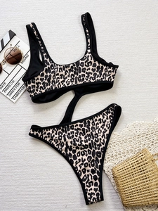 Leopard print cutout one-piece swimsuit with black straps on a vacation style background