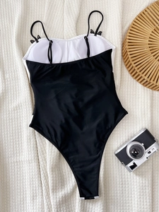 Classic black and white one-piece swimsuit with spaghetti straps on waffle fabric