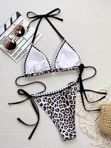 Two-piece leopard print bikini set with halter top and tie-side bottoms on beach props