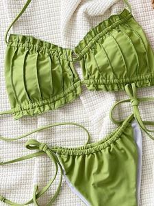 Detail of green ribbed bikini set featuring textured fabric and side-tie bottoms