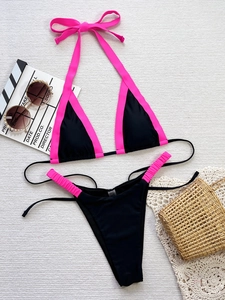Flachbild-Detail eines schwarzen Bikinis mit rosa Rand, Nackenträger und hohem Beinausschnitt