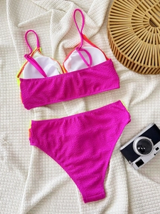 Detailed macro view of vibrant pink seersucker fabric texture on a two-piece bikini set