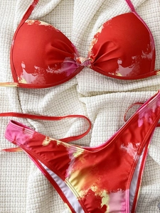 Flat lay of a red tie-dye two-piece bikini with twist front top and high cut bottoms