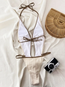 Flat lay of halter one-piece swimsuit with bow details and vintage vacation props