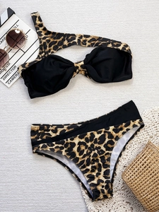 Two-piece leopard print bikini set with one-shoulder top and high-waisted bottoms on white fabric
